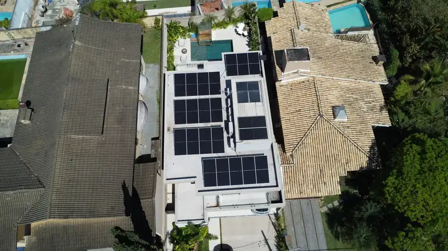 Sistema de energia solar instalado em residência de arquitetura moderna com piscina
